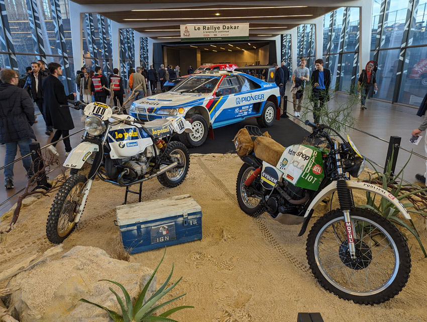 Magnifique exposition consacrée au Paris Dakar. A gauche, la BMW victorieuse d’Hubert Auriol en 1983 devant la Peugeot 405 d’Ari Vatanen