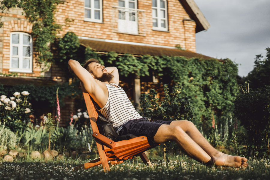 Homme se relaxe dans son jardin au soleil