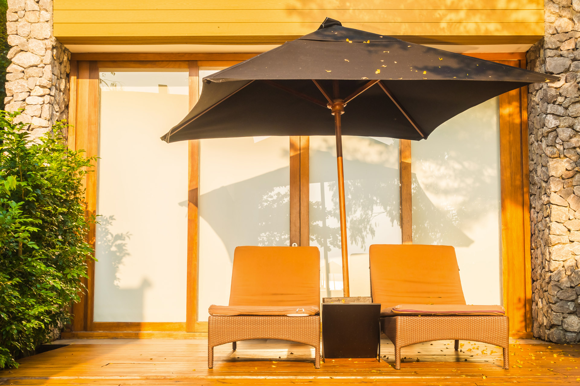 Terrasse maison avec fauteuils et parasol