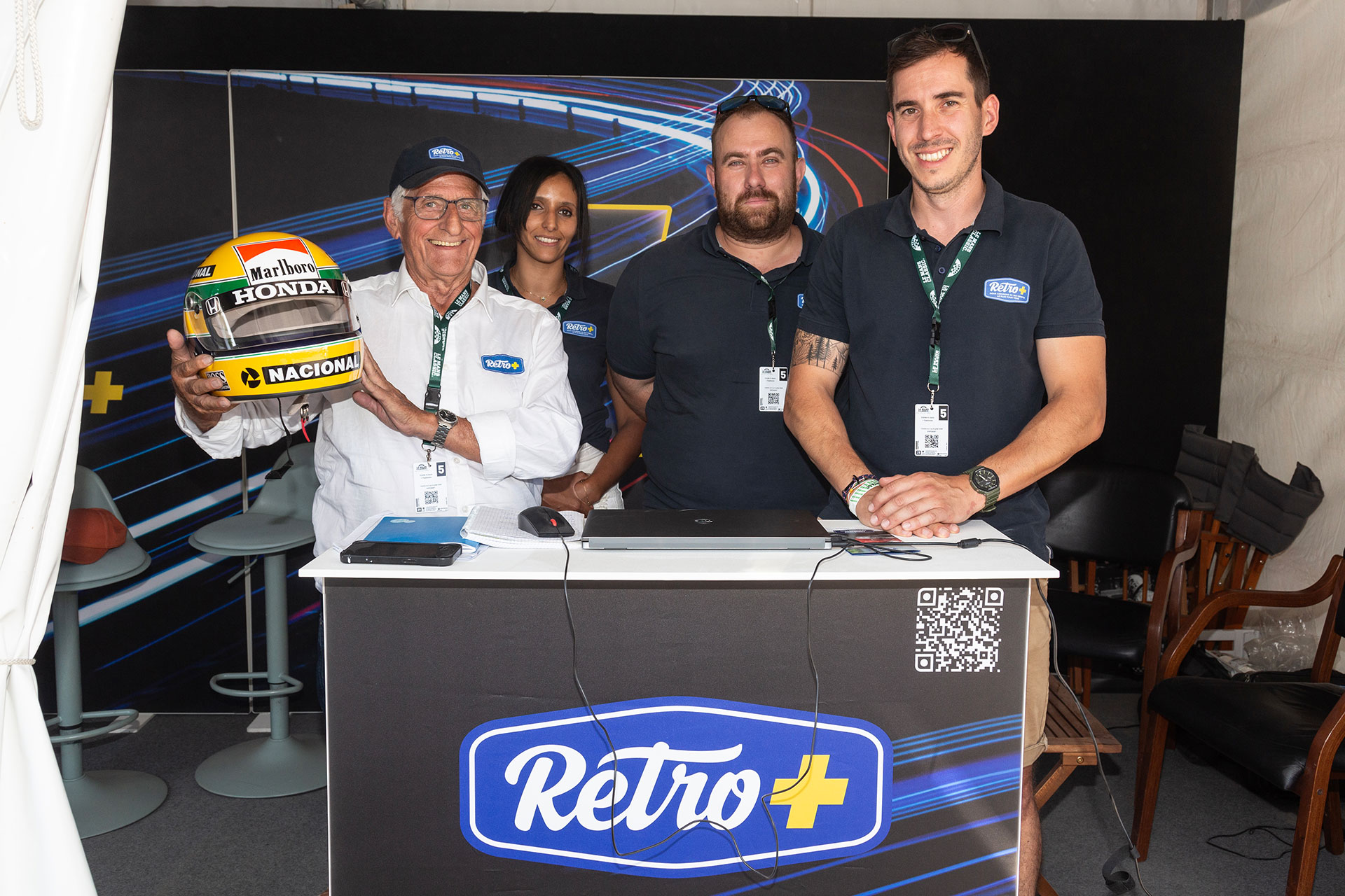 Equipe Rétro+ sur le stand au Mans Classic 2025 avec la réplique du casque d'Ayton Senna